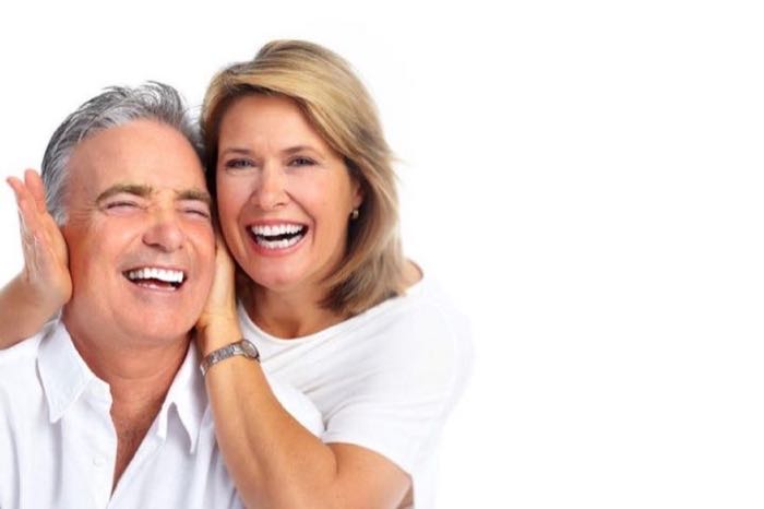 A couple smiling after emergency dental treatment